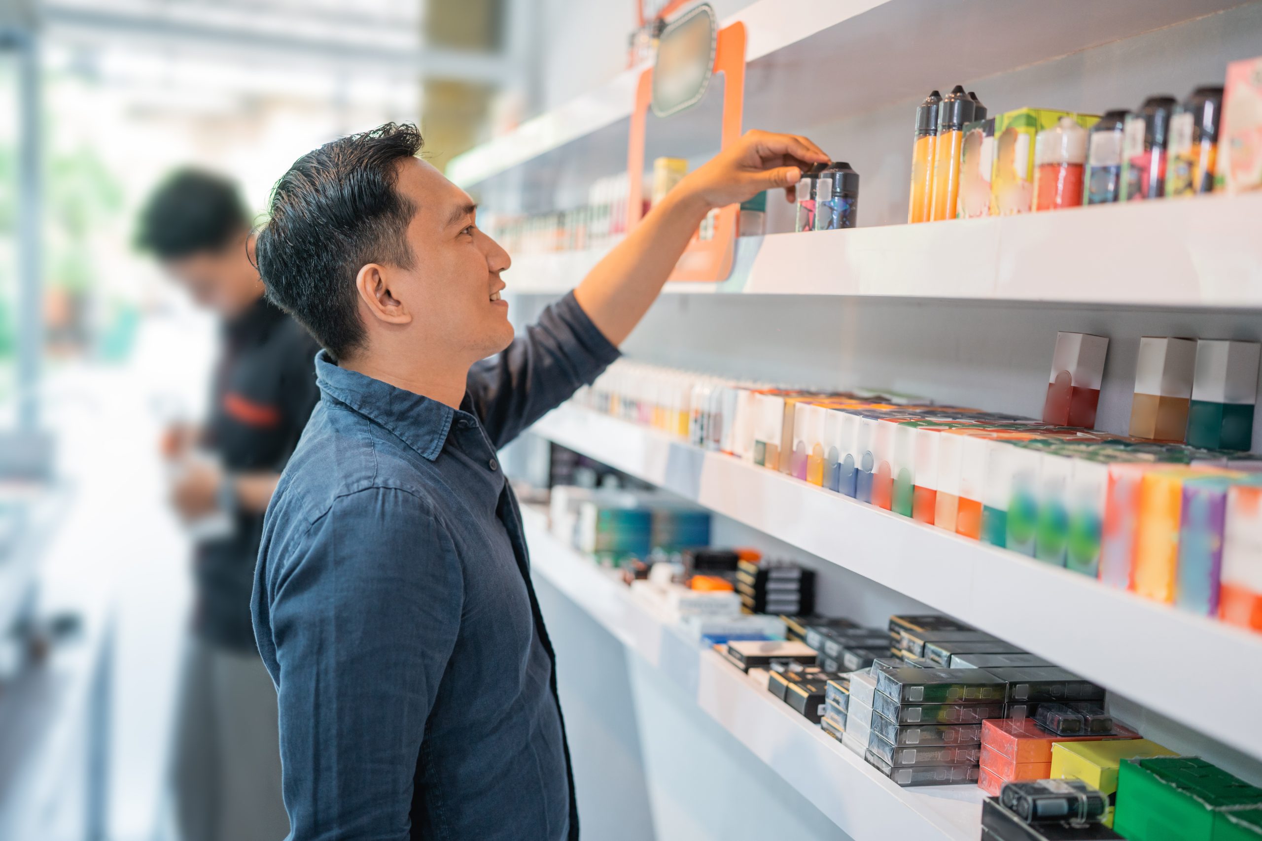 Man browsing vape products on store shelves, showcasing retail strategies for effective alternative ingredient marketing and customer engagement.