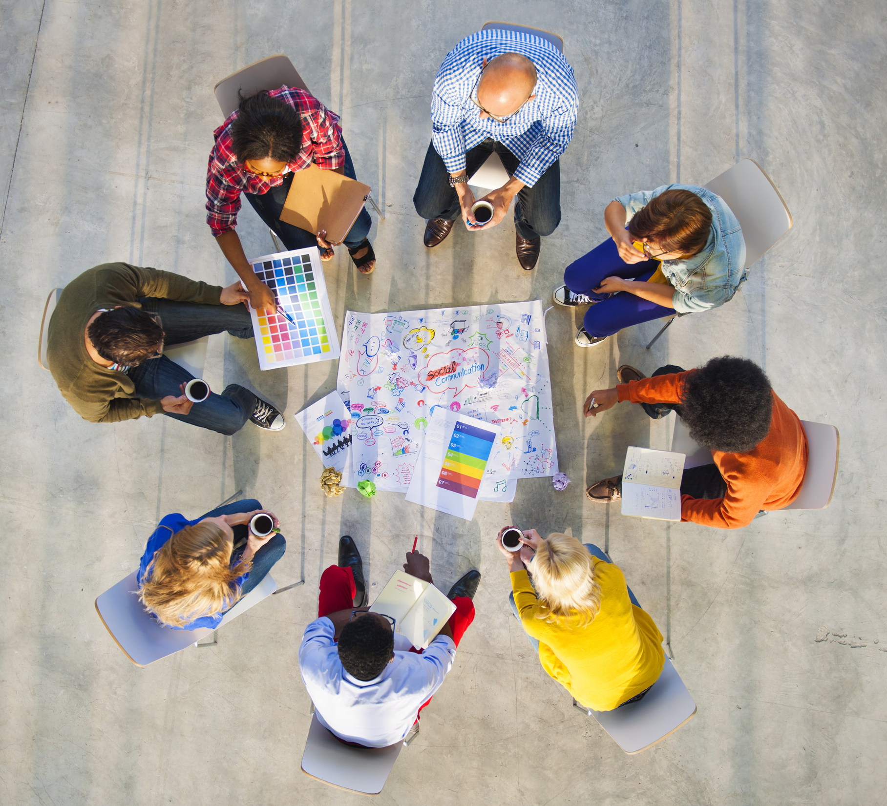 Group sitting in a circle collaborating to come up with new ideas. 